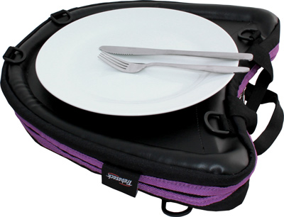 Image shows the purple-trim Trabasack Curve on a flat surface with a plate and cutlery on the tray surface