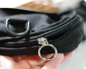Image shows a close-up of the large ring-pull zips of the bag compartment of the Trabasack Mini Connect