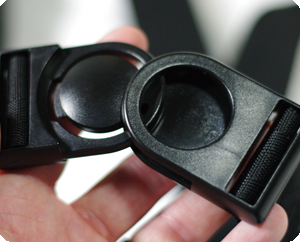 Image shows a close-up of a hand holding the Trabasack quick-release buckles